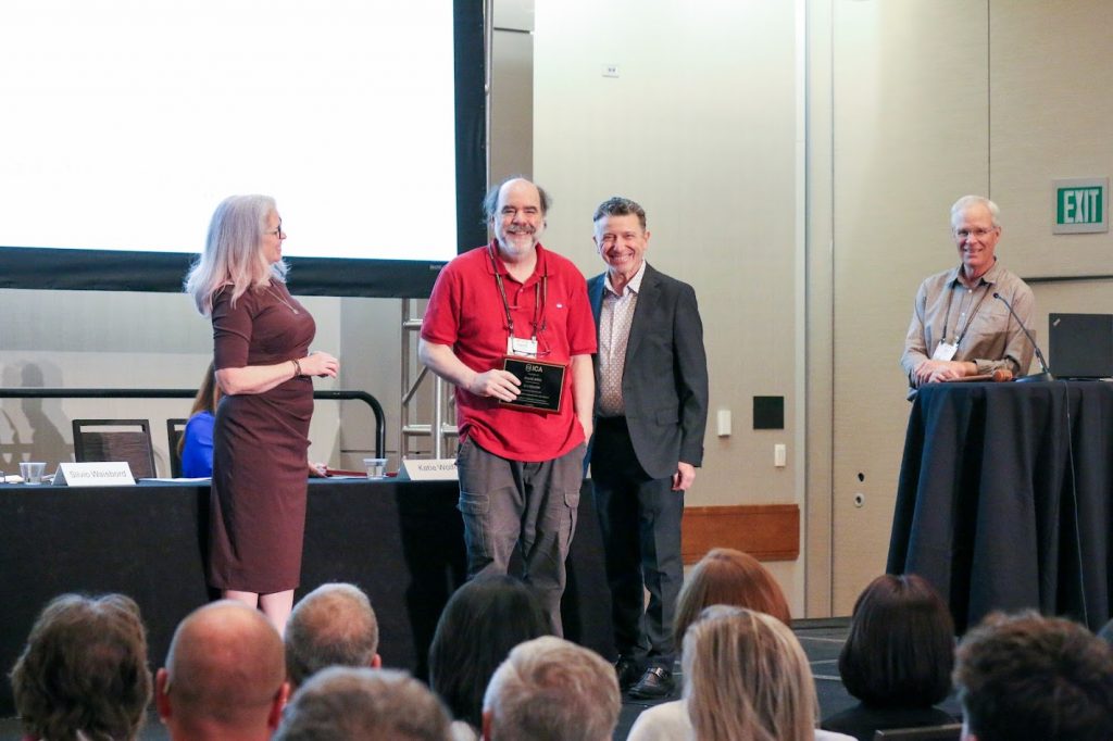 Dr. David Atkin receiving fellowship award on stage.