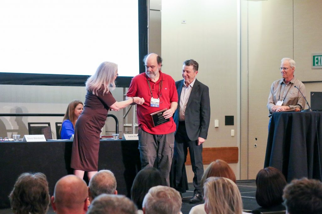 Dr. David Atkin shaking hands with person bestowing award.